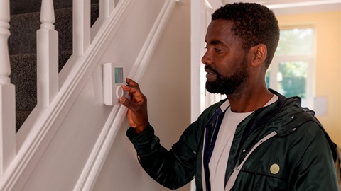 Une personne diminue le thermostat du chauffage